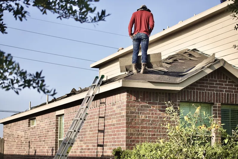Professional roofer working on a residential roof in Thompson Riverview Terrace